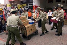 Relief supplies arrive near crumbled hotel
